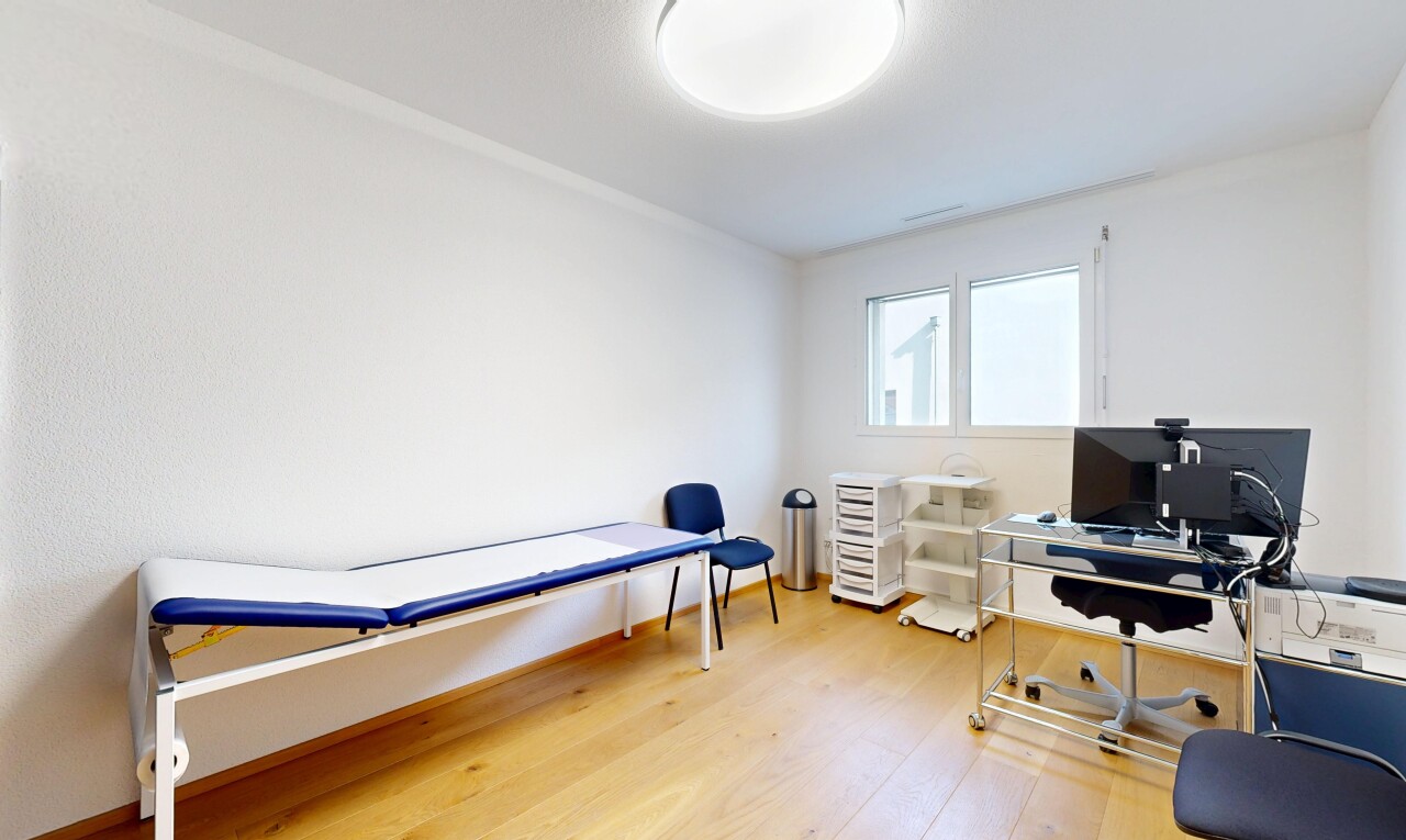chambre avec sol en finition bois, télévision, espace bureau, lumière naturelle, et cloison sèche