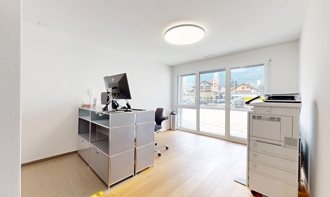 bureau avec télévision, cloison sèche, espace bureau, plinthes murales, et lumière naturelle