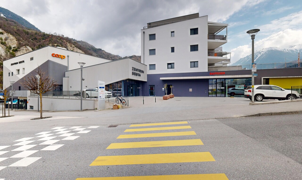 extérieur du bâtiment avec vue sur la montagne, parking, et vue commerciale