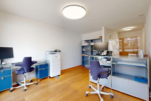 bureau avec espace bureau, télévision, et sol en finition bois
