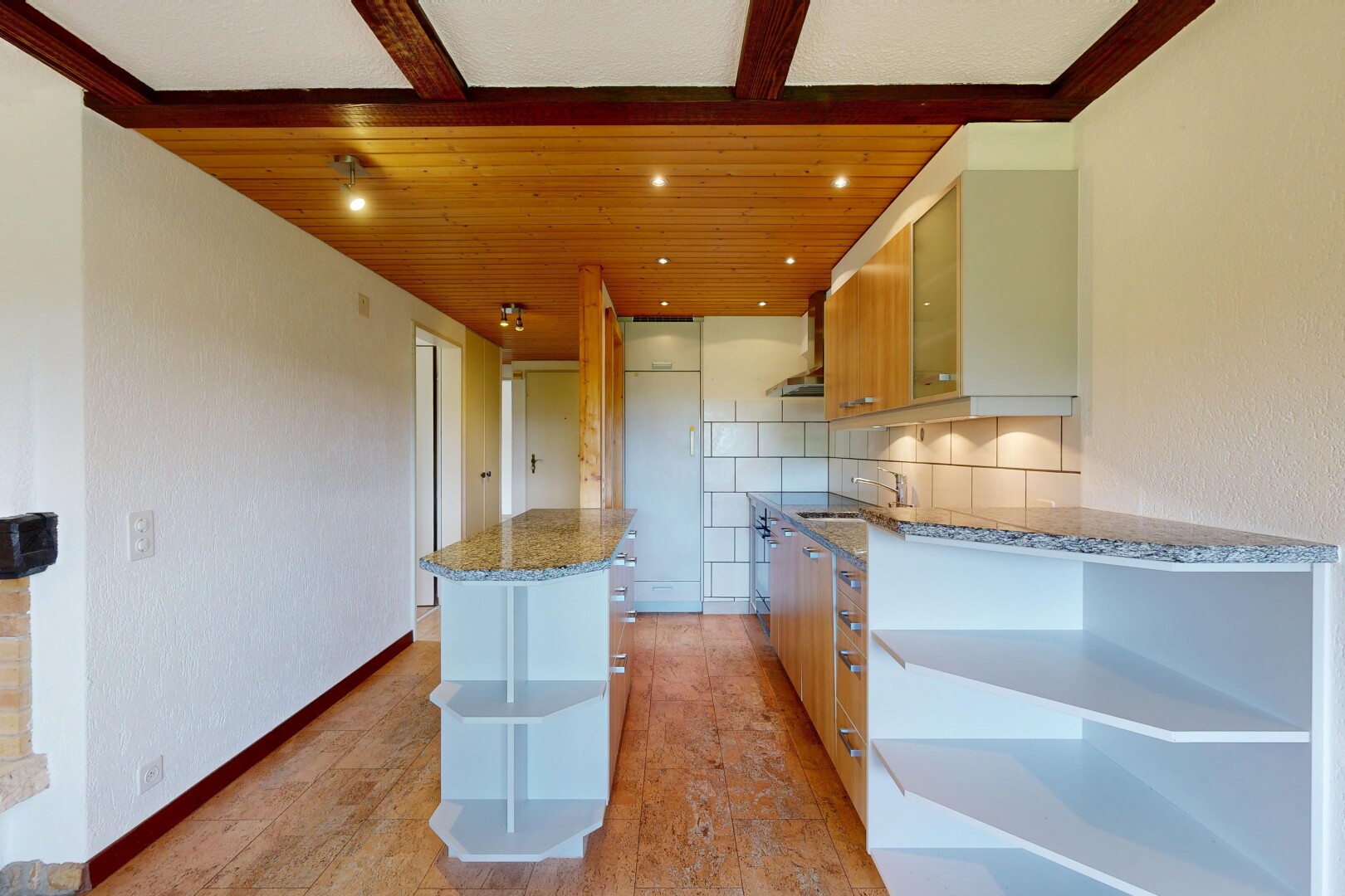 cuisine avec plans de travail en pierre, dosseret, backsplash, inside property, et îlot de cuisine