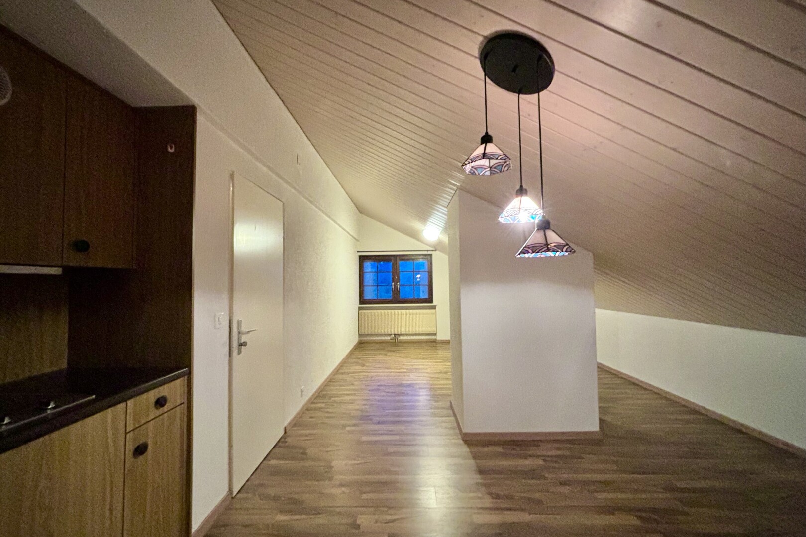 couloir avec vaulted ceiling, plafond voûté, wood finish floor, sol en finition bois, et inside property