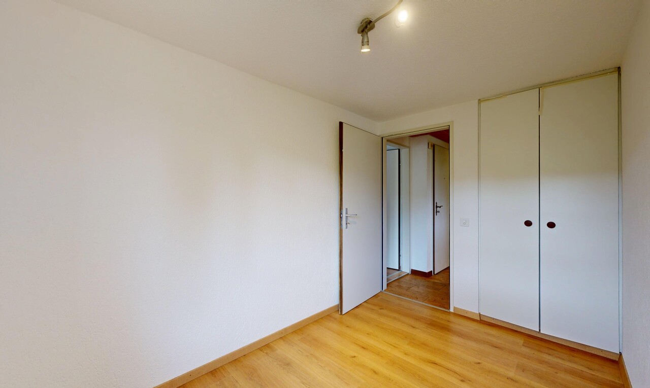 pièce vide avec inside property, cloison sèche, drywall, sol en finition bois, et wood finish floor