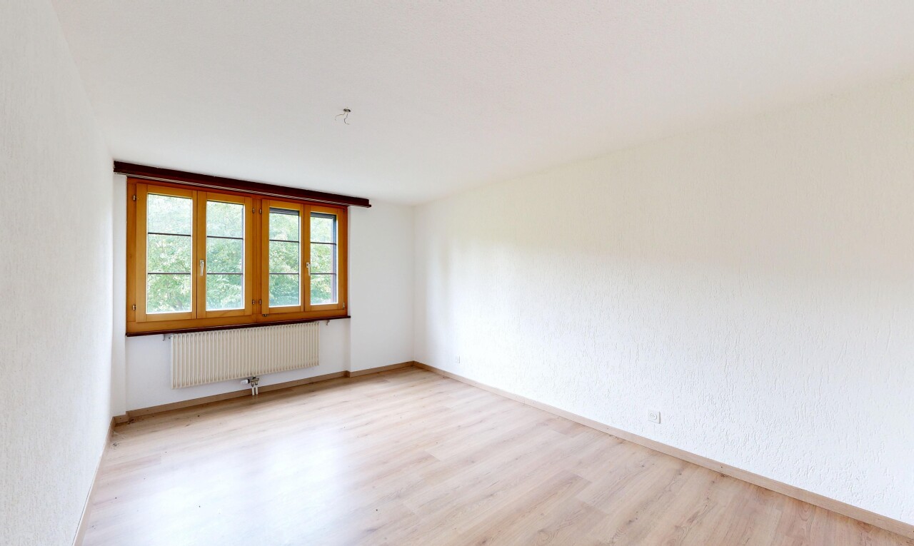 pièce vide avec sol en finition bois, wood finish floor, lumière naturelle, natural light, et radiateur