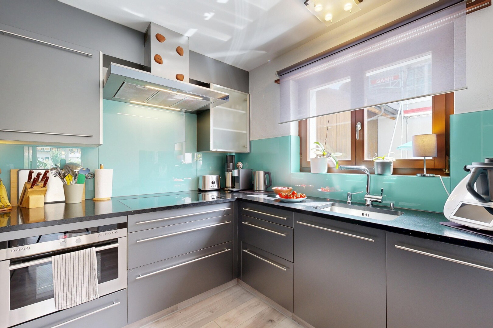 küche mit dunstabzugshaube, dark countertops, mikrowelle, inside property, und waschbecken