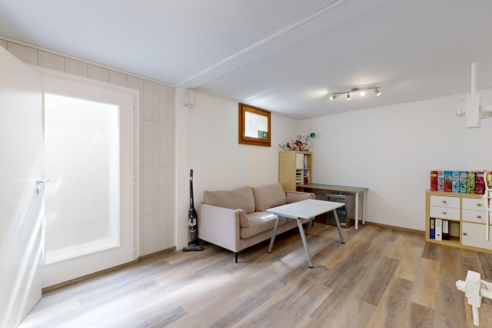 wohnzimmer mit inside property, holzfußboden, wood finish floor, keller, und gipskartonwand