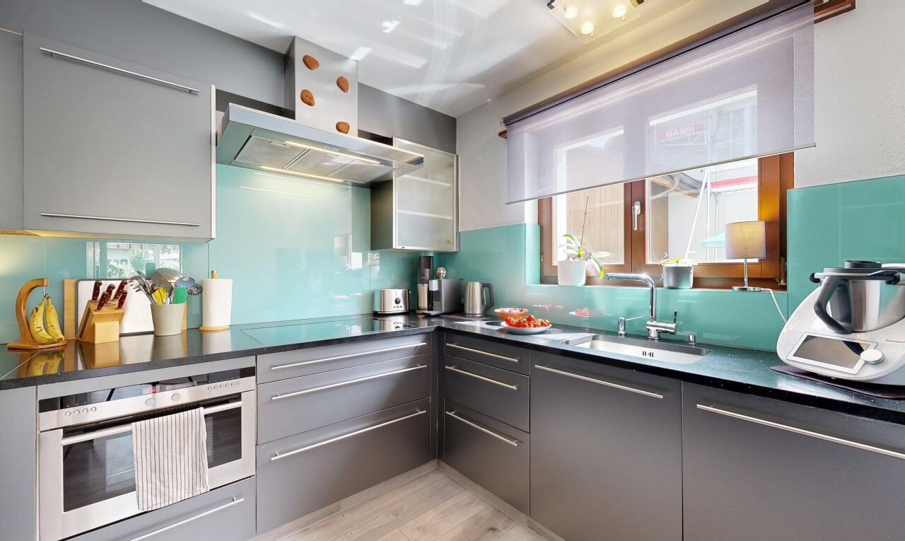 küche mit dunstabzugshaube, dark countertops, mikrowelle, inside property, und waschbecken