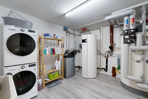 buanderie avec inside property, lave-linge et sèche-linge superposés, sol en finition bois, wood finish floor, et sous-sol
