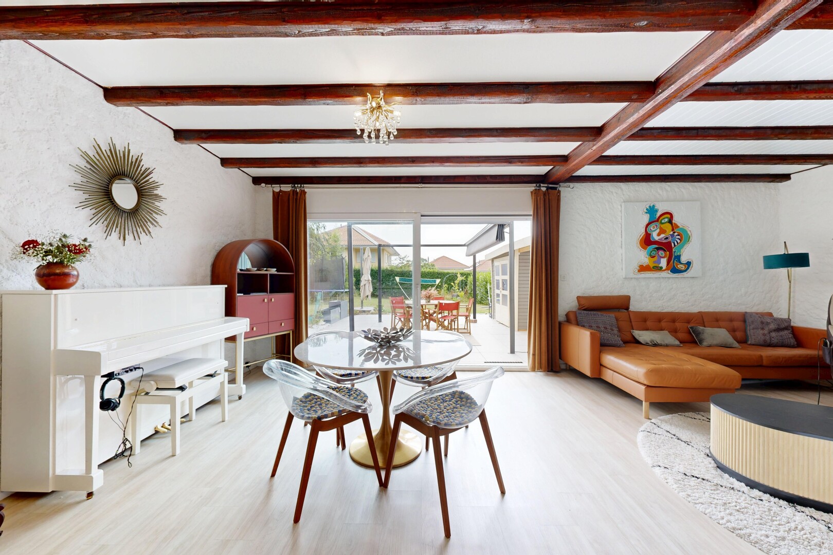 salon / salle à manger avec beamed ceiling, plafond à poutres, wood finish floor, sol en finition bois, et natural light