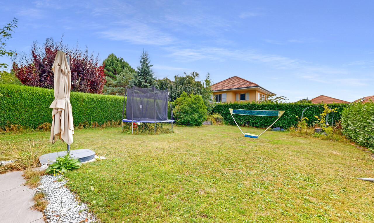 jardin avec trampoline, pelouse, day time, et property visible