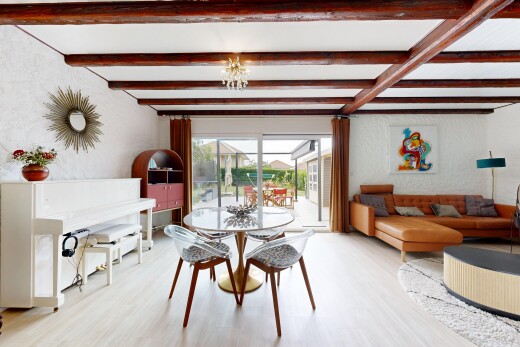 salon / salle à manger avec beamed ceiling, plafond à poutres, wood finish floor, sol en finition bois, et natural light
