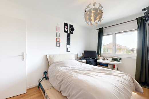 chambre avec sol en finition bois, wood finish floor, cloison sèche, drywall, et lumière naturelle