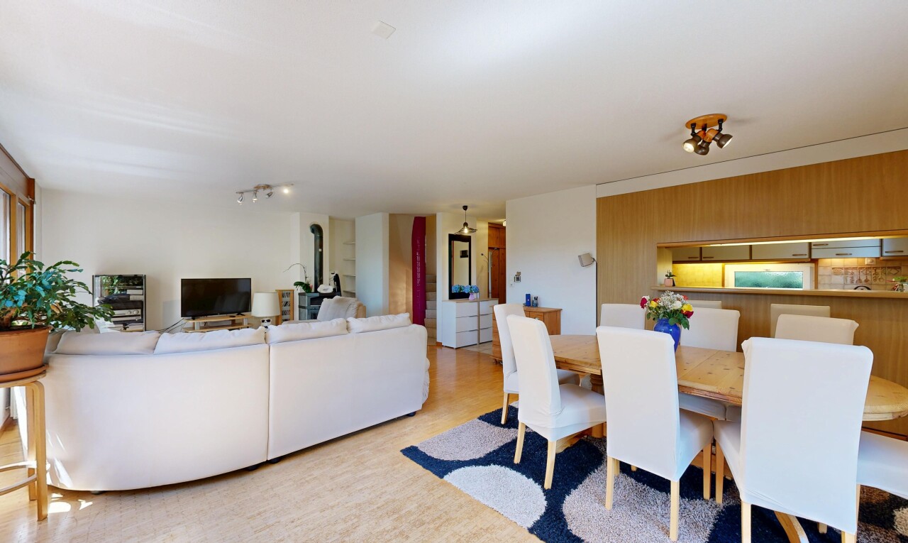 living / dining area featuring arched walkways, track lighting, and light wood finished floors