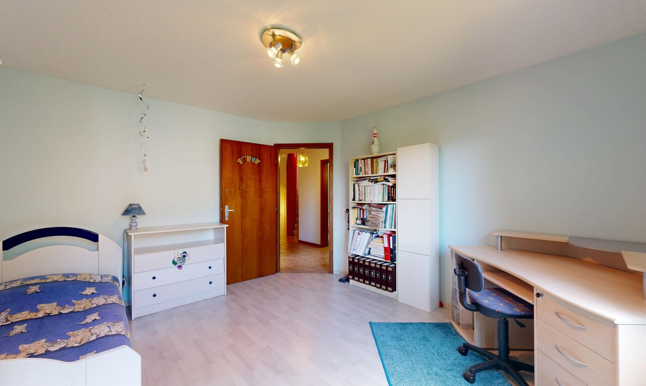 room with a desk and light wood-style flooring