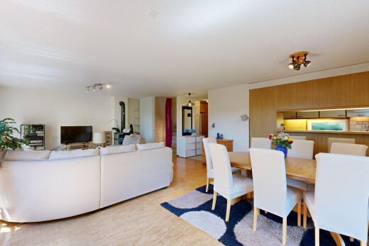living / dining area featuring arched walkways, track lighting, and light wood finished floors