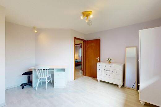 chambre avec drywall, cloison sèche, inside property, espace bureau, et wood finish floor