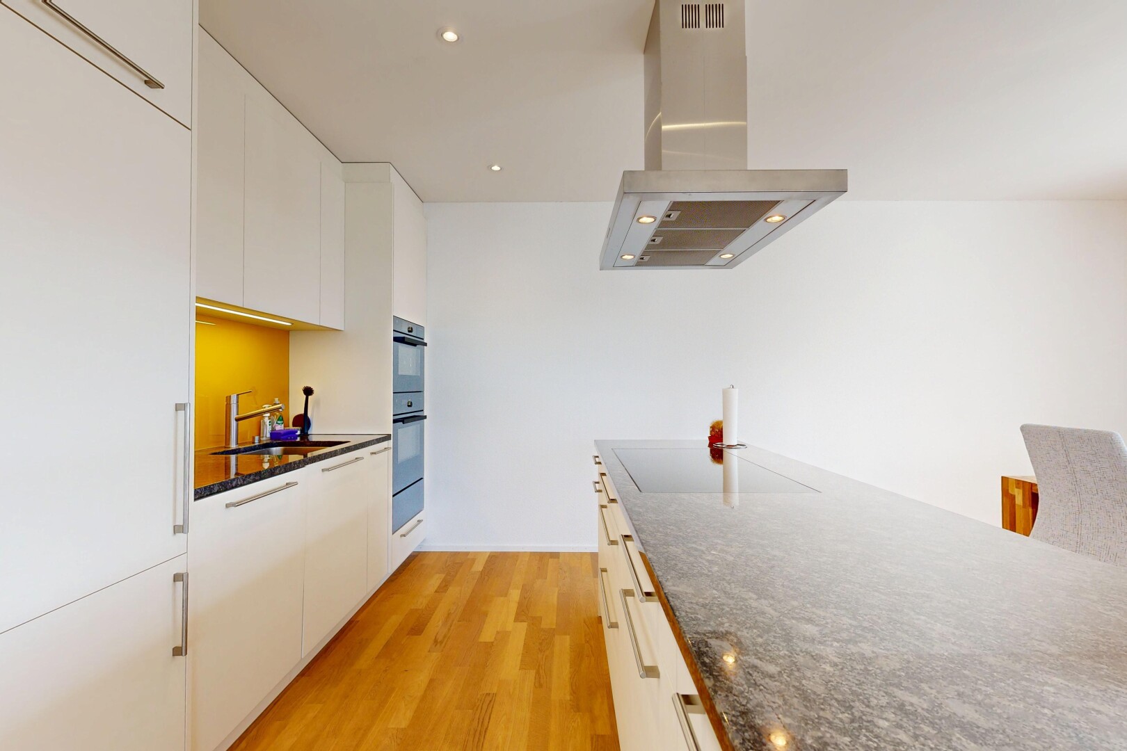 küche mit dunstabzugshaube, holzfußboden, wood finish floor, dark countertops, und light floor