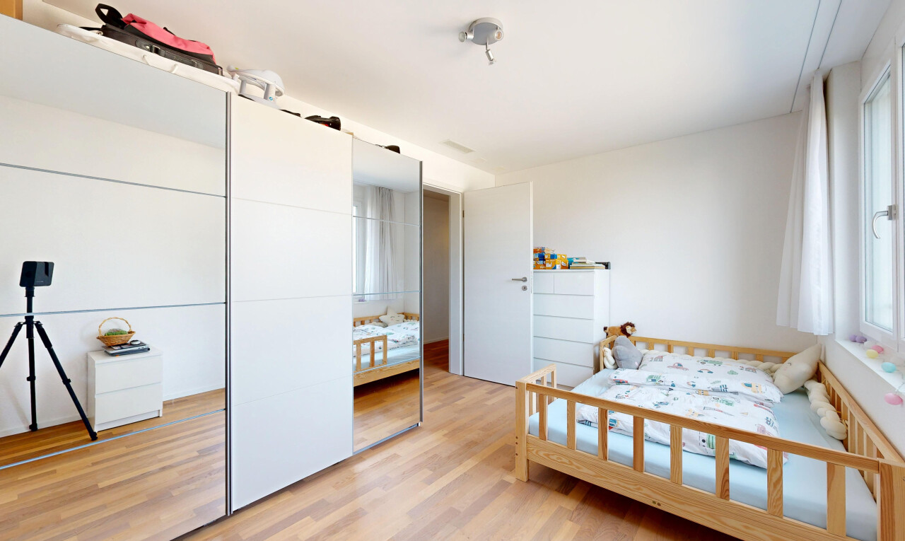 zimmer / schlafzimmer mit wood finish floor, holzfußboden, drywall, gipskartonwand, und kleiderschrank