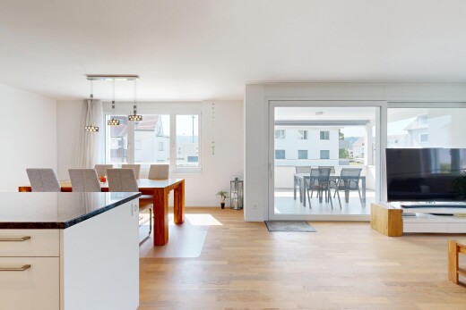 wohn- / esszimmer mit fernseher, wood finish floor, holzfußboden, light floor, und drywall
