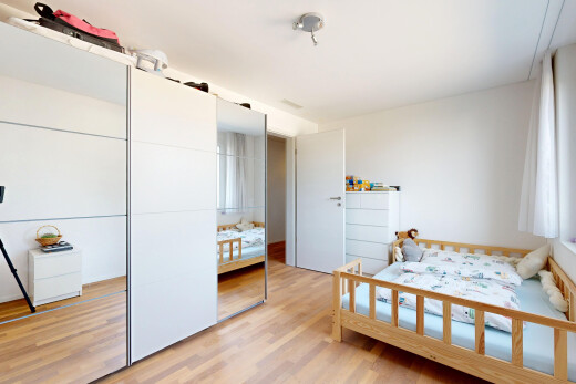 zimmer / schlafzimmer mit wood finish floor, holzfußboden, drywall, gipskartonwand, und kleiderschrank