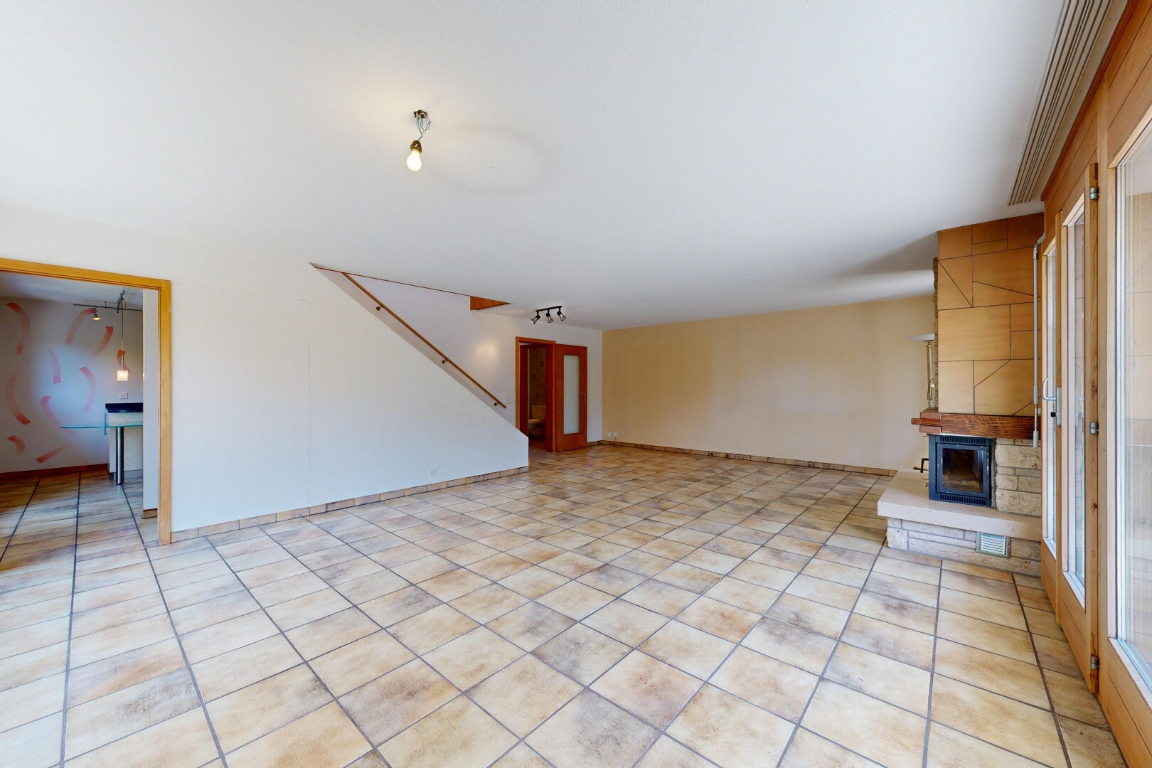 wohnzimmer mit treppen, drywall, gipskartonwand, light floor, und inside property