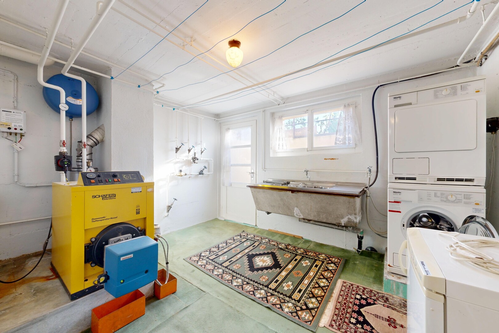wäschekammer mit heizkessel, concrete floor, betonboden, inside property, und natural light