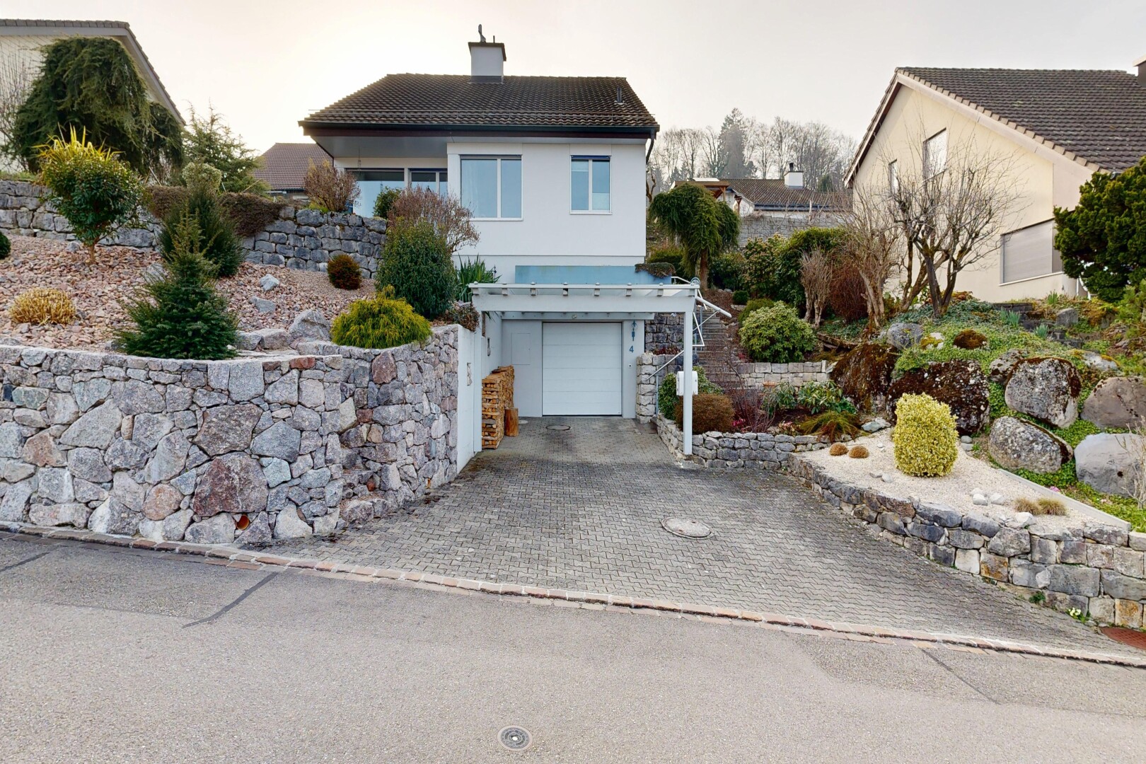 façade avec garage intégré, property visible, bardage en stuc, allée, et cheminée