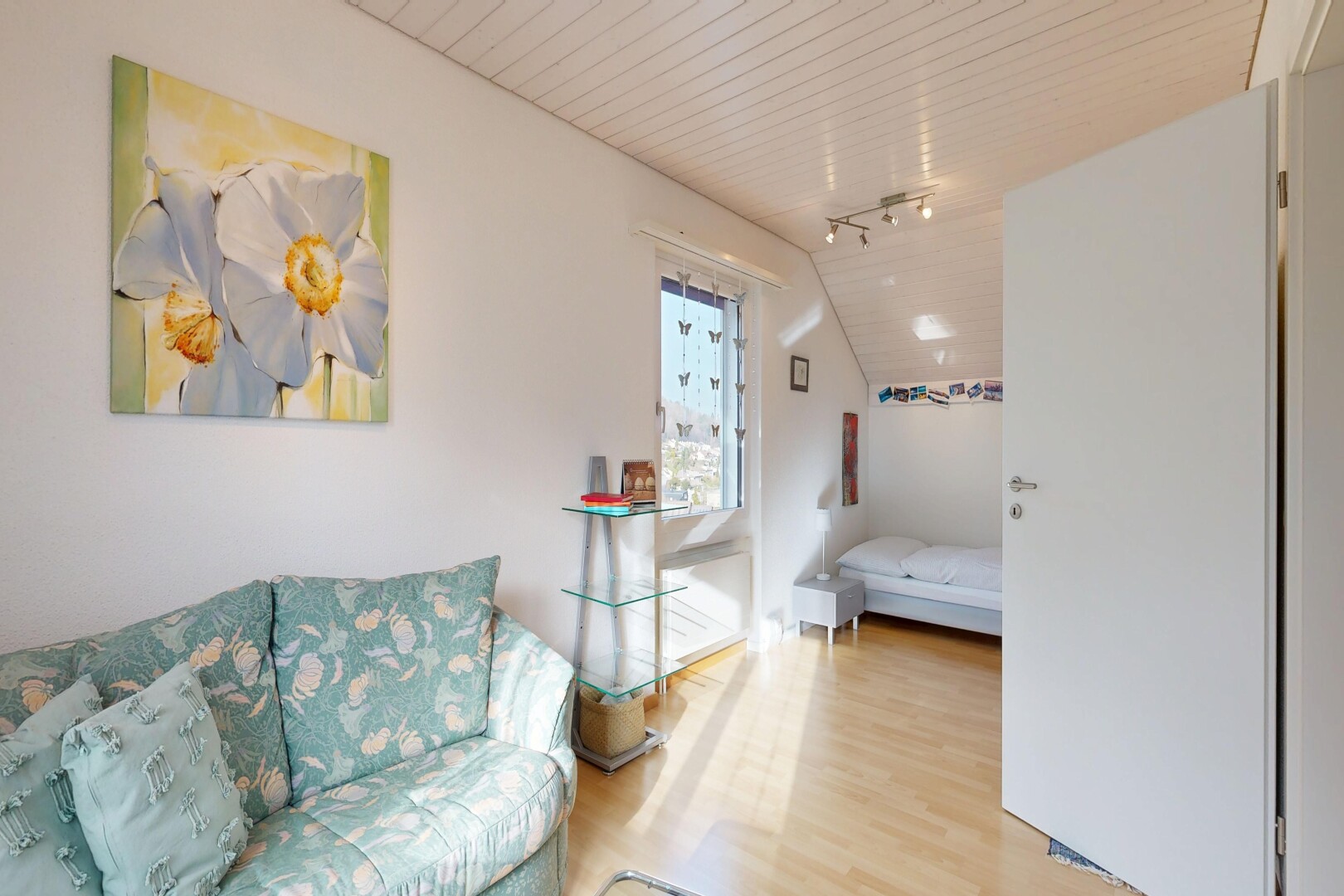 salon avec inside property, éclairage sur rail, track lighting, sol en finition bois, et wood finish floor
