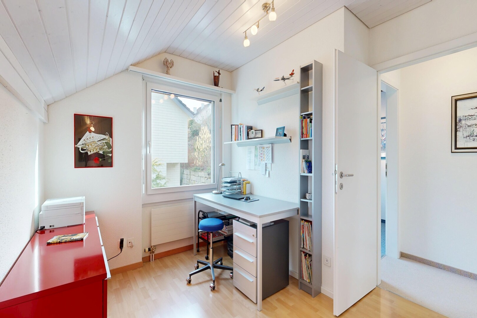 bureau avec espace bureau, sol en finition bois, wood finish floor, inside property, et lumière naturelle
