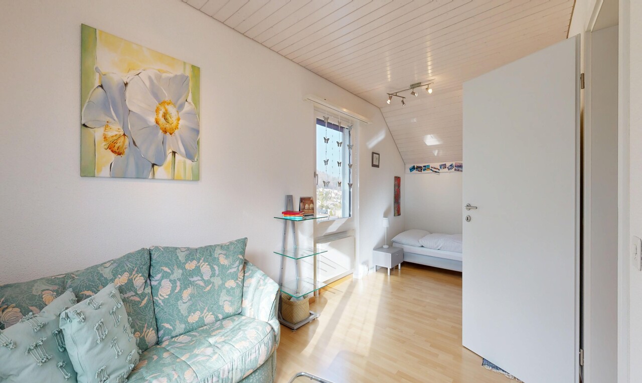 salon avec inside property, éclairage sur rail, track lighting, sol en finition bois, et wood finish floor