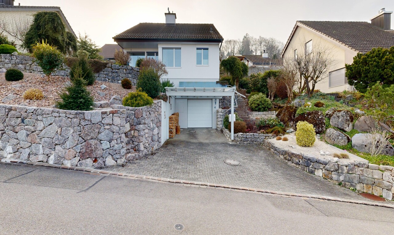 façade avec garage intégré, property visible, bardage en stuc, allée, et cheminée