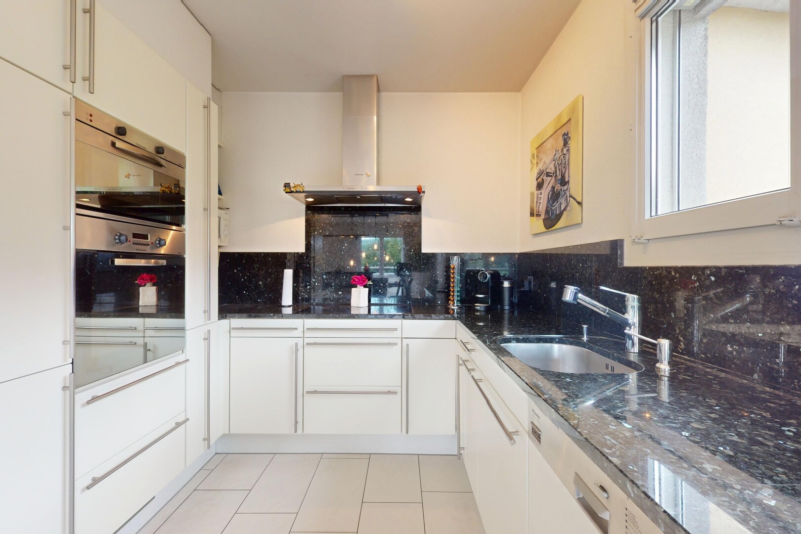 cuisine avec hotte, backsplash, dosseret, inside property, et armoires blanches
