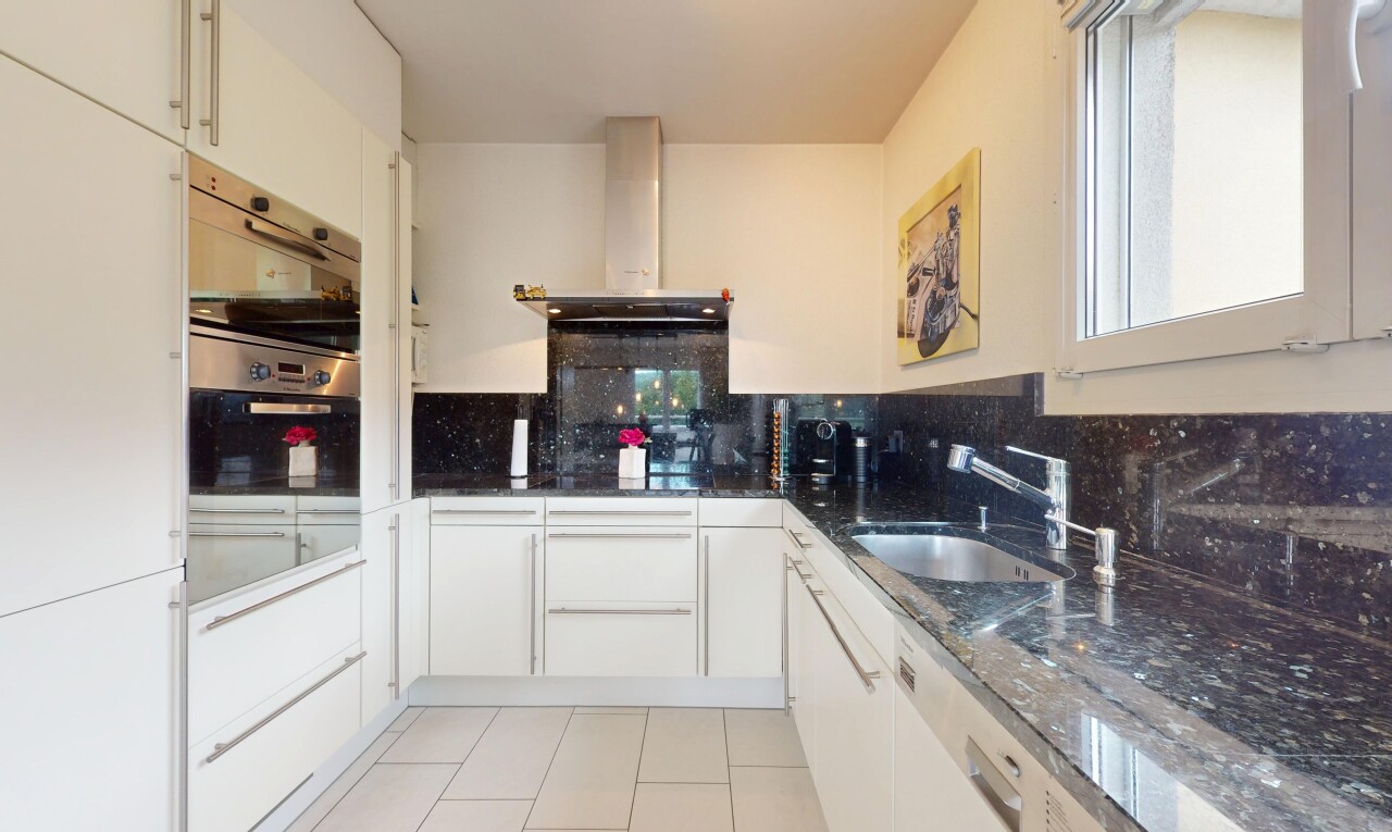 cuisine avec hotte, backsplash, dosseret, inside property, et armoires blanches