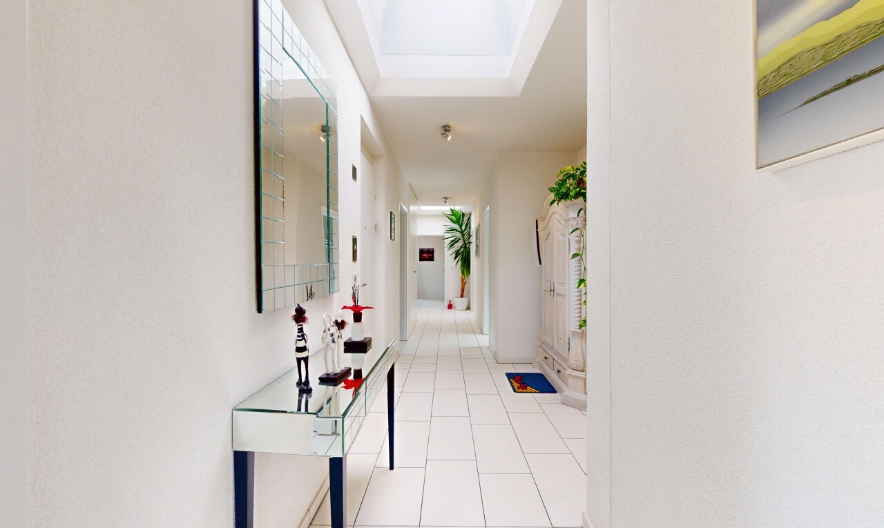 couloir avec inside community, tile floor, sol en carrelage, tray ceiling, et plafond à plateaux