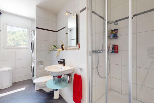 salle de bains avec lave-linge et sèche-linge superposés, tile wall, mur en carrelage, miroir, et douche