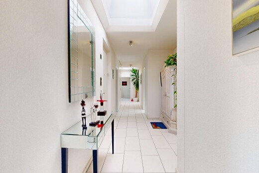 couloir avec inside community, tile floor, sol en carrelage, tray ceiling, et plafond à plateaux