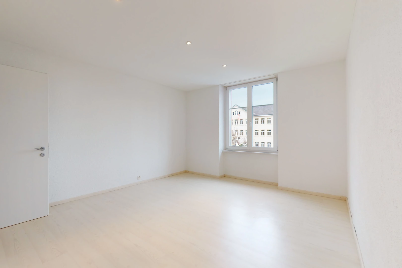 chambre vide avec parquet et lumière naturelle