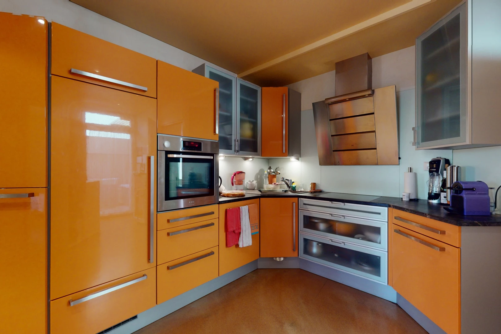 cuisine avec acier inoxydable, four, plan de travail foncé, et meubles marron