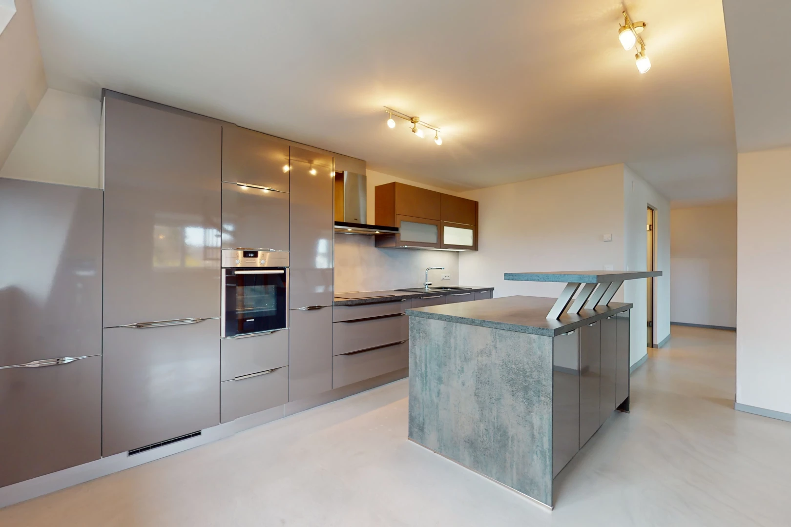 cuisine avec acier inoxydable, hotte, four, sol clair, et meubles marron