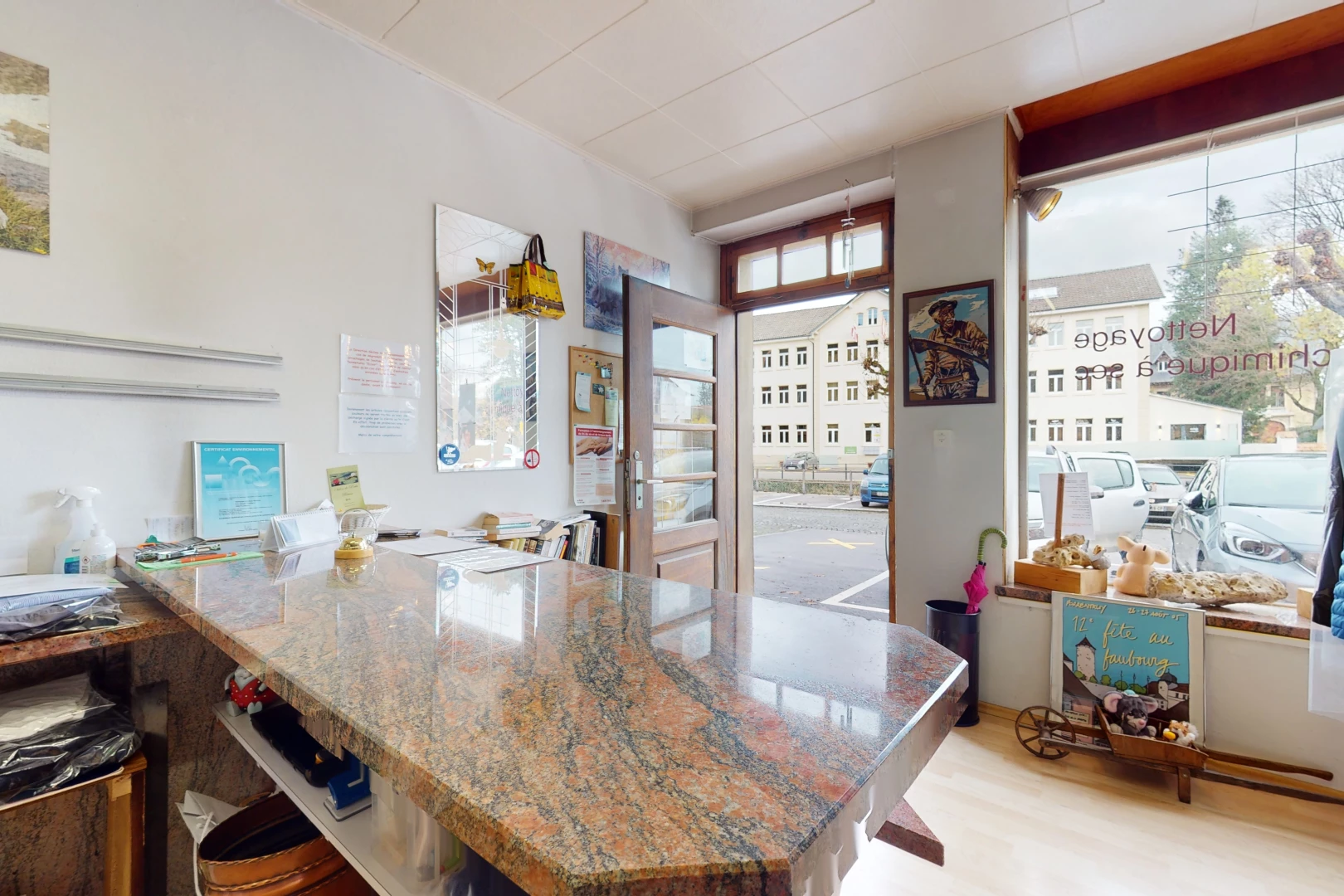 cuisine avec bar, parquet, lumière naturelle, sol clair, plan de travail foncé, et plan de travail en pierre