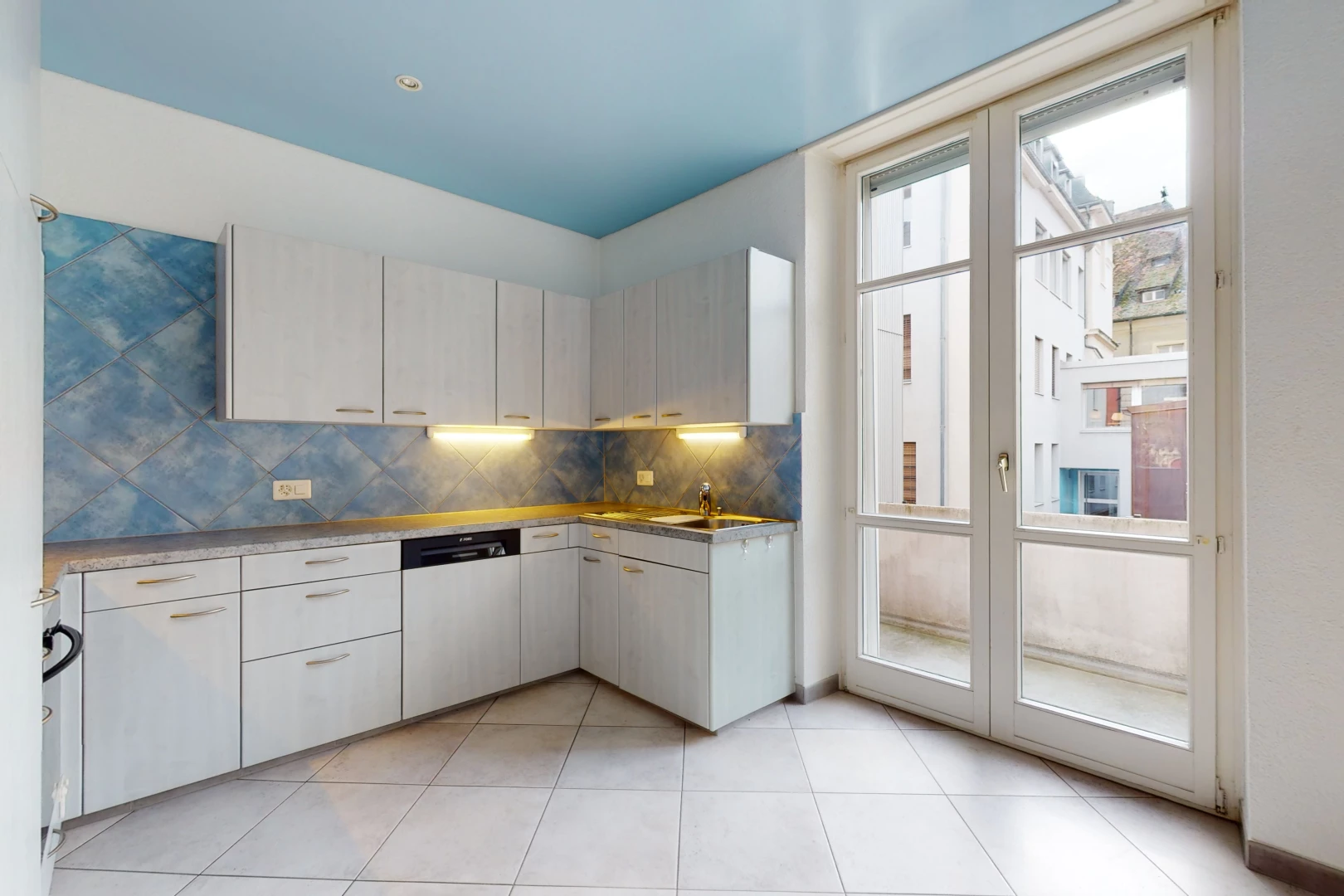 cuisine avec lumière naturelle, carrelage, sol clair, et meubles blancs