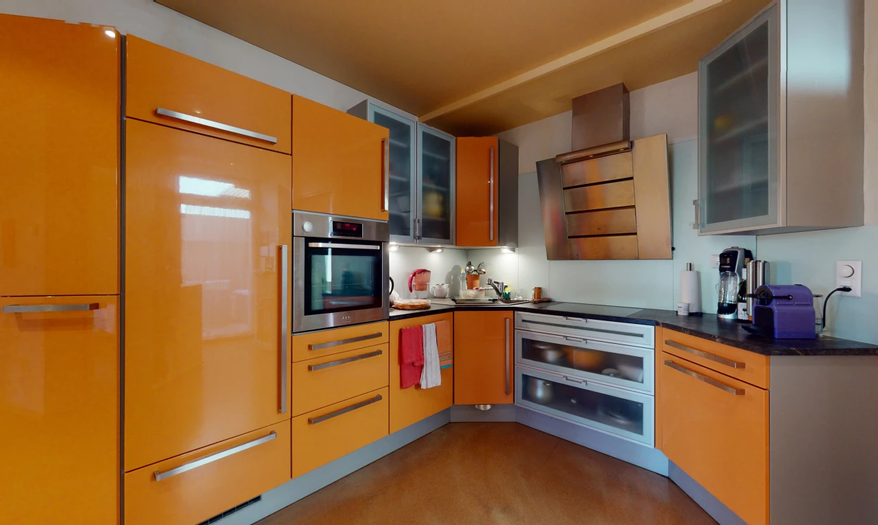 cuisine avec acier inoxydable, four, plan de travail foncé, et meubles marron