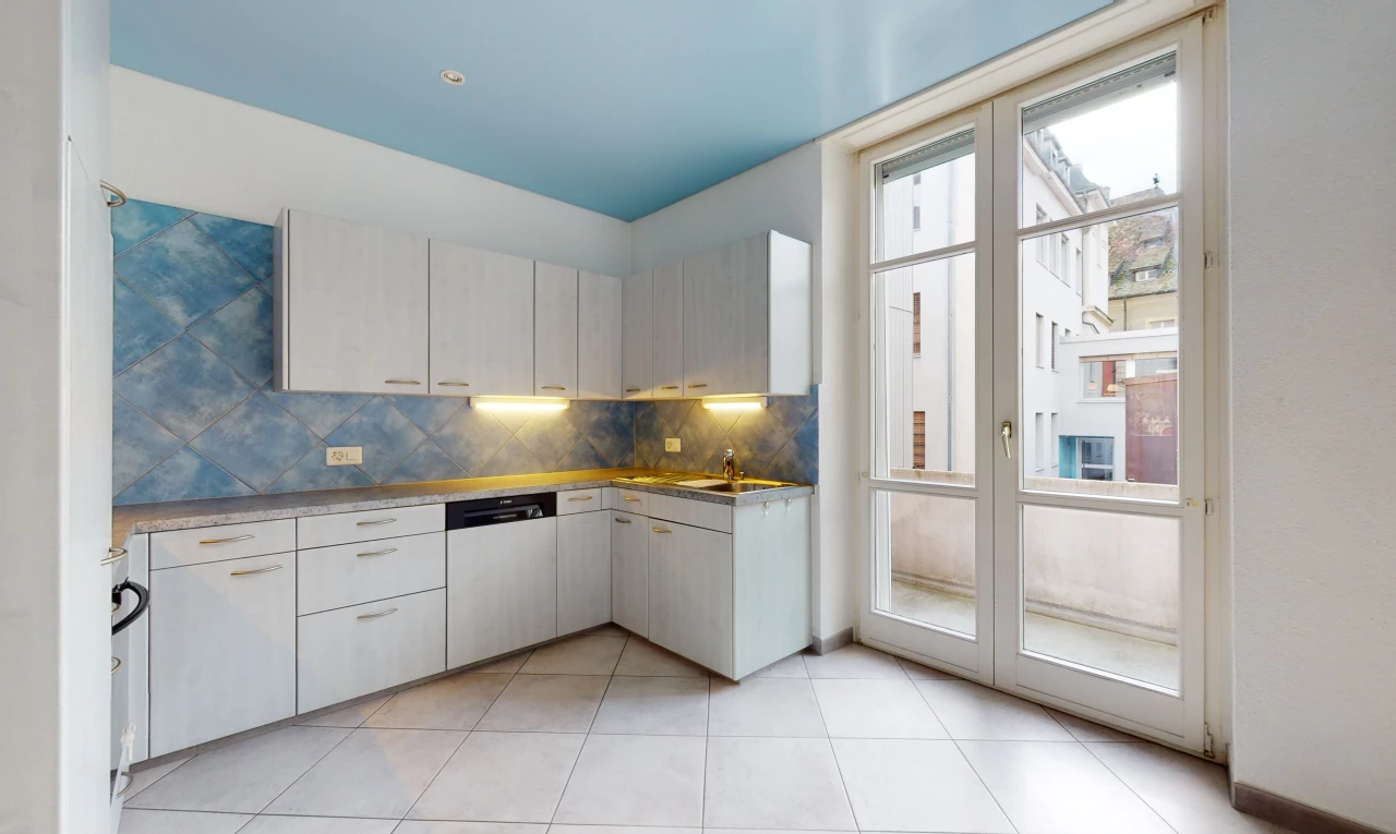 cuisine avec lumière naturelle, carrelage, sol clair, et meubles blancs