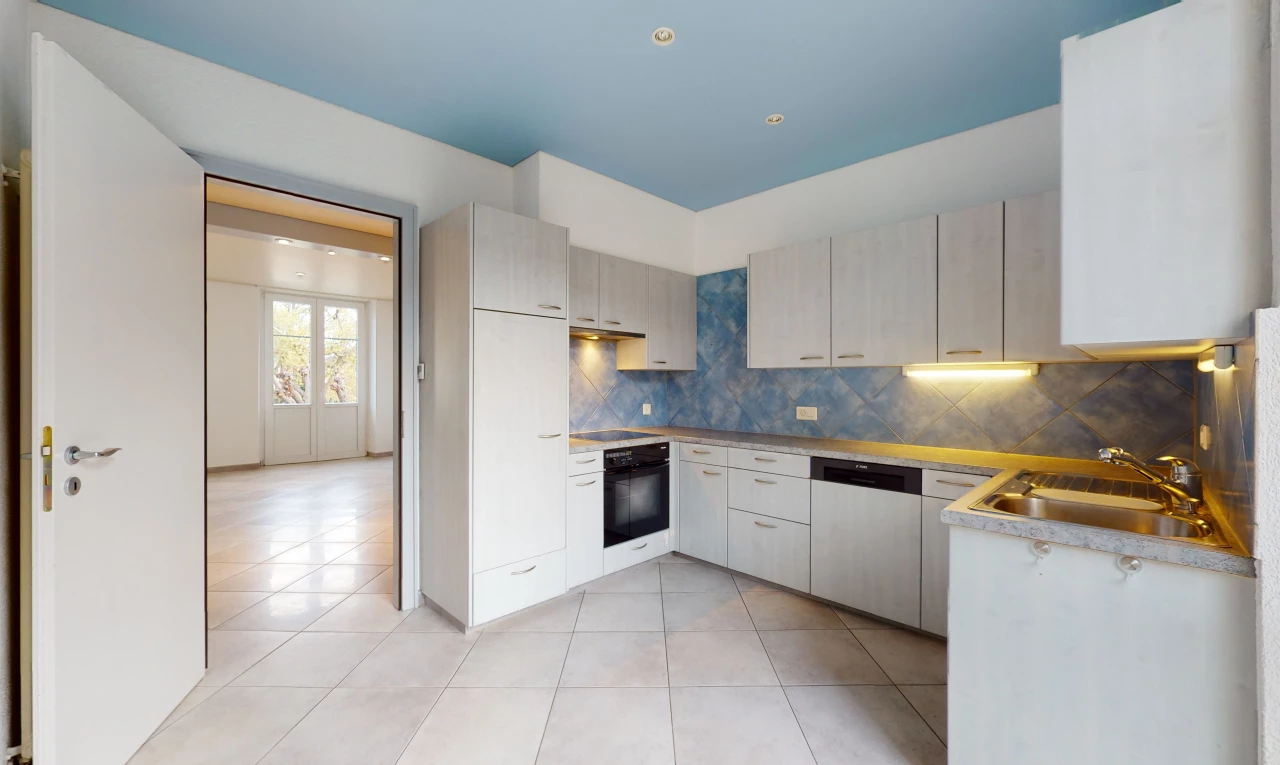 cuisine avec lumière naturelle, carrelage, four, lave-vaisselle, sol clair, et meubles blancs