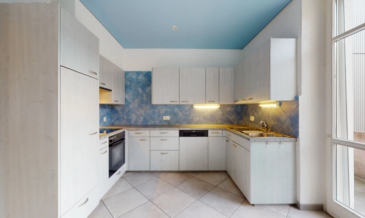 cuisine avec carrelage, lave-vaisselle, cuisinière électrique, four, plan de travail foncé, sol clair, et meubles blancs