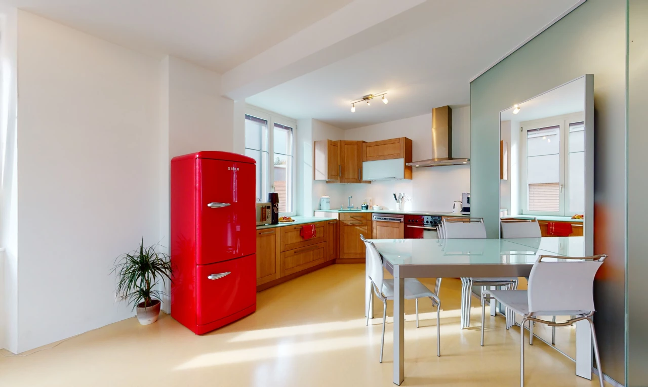 cuisine avec lumière naturelle, hotte, plan de travail clair, sol clair, et meubles marron