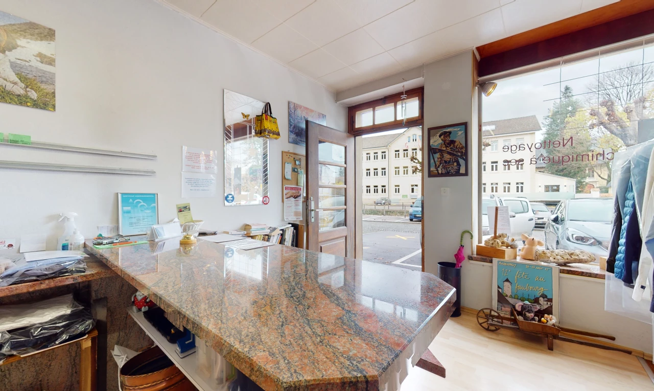 cuisine avec bar, parquet, lumière naturelle, sol clair, plan de travail foncé, et plan de travail en pierre