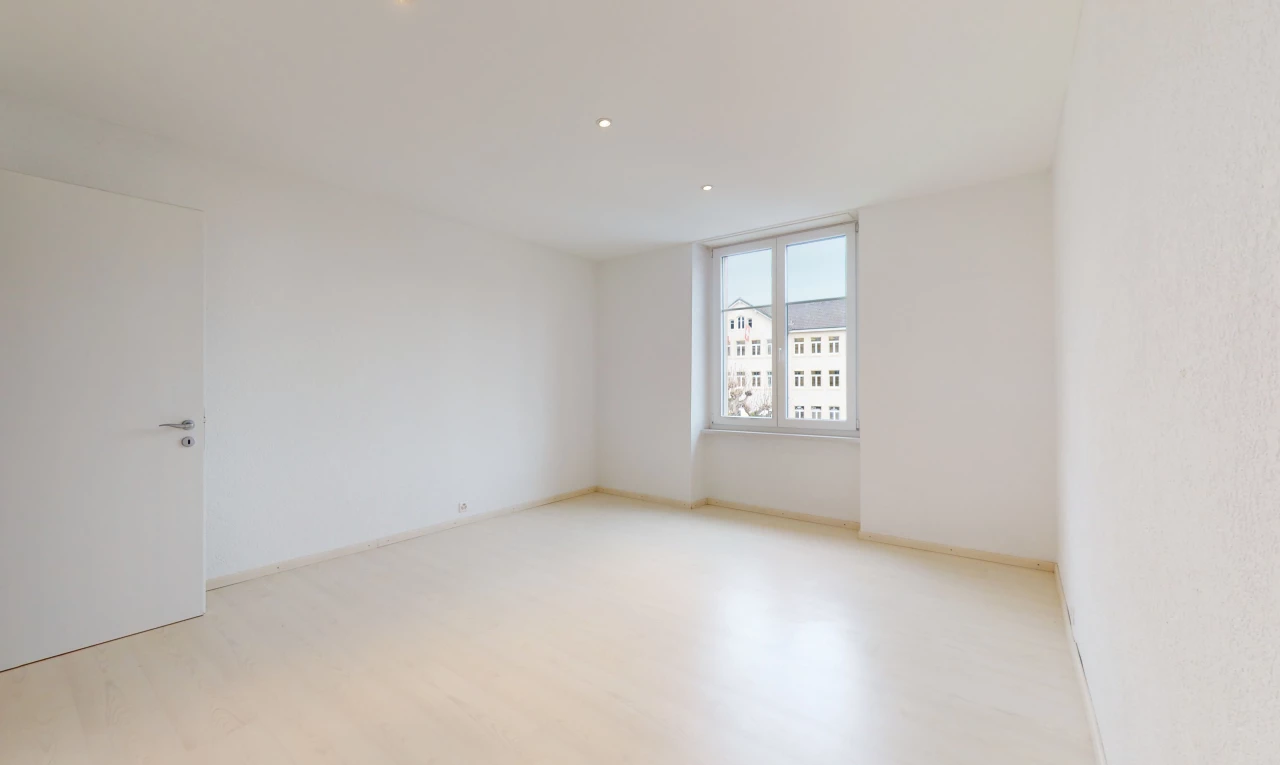chambre vide avec parquet et lumière naturelle