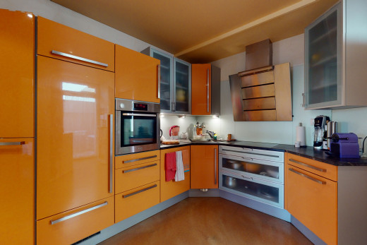 küche mit edelstahlofen, dunklen arbeitsplatten und braunen schränken