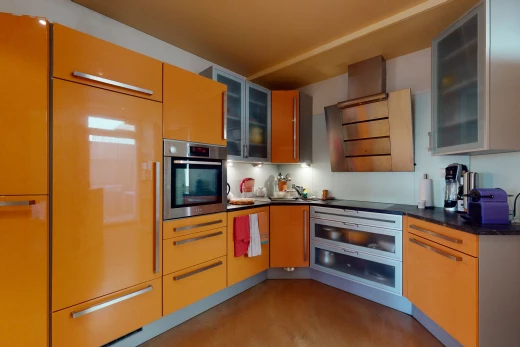 cuisine avec acier inoxydable, four, plan de travail foncé, et meubles marron
